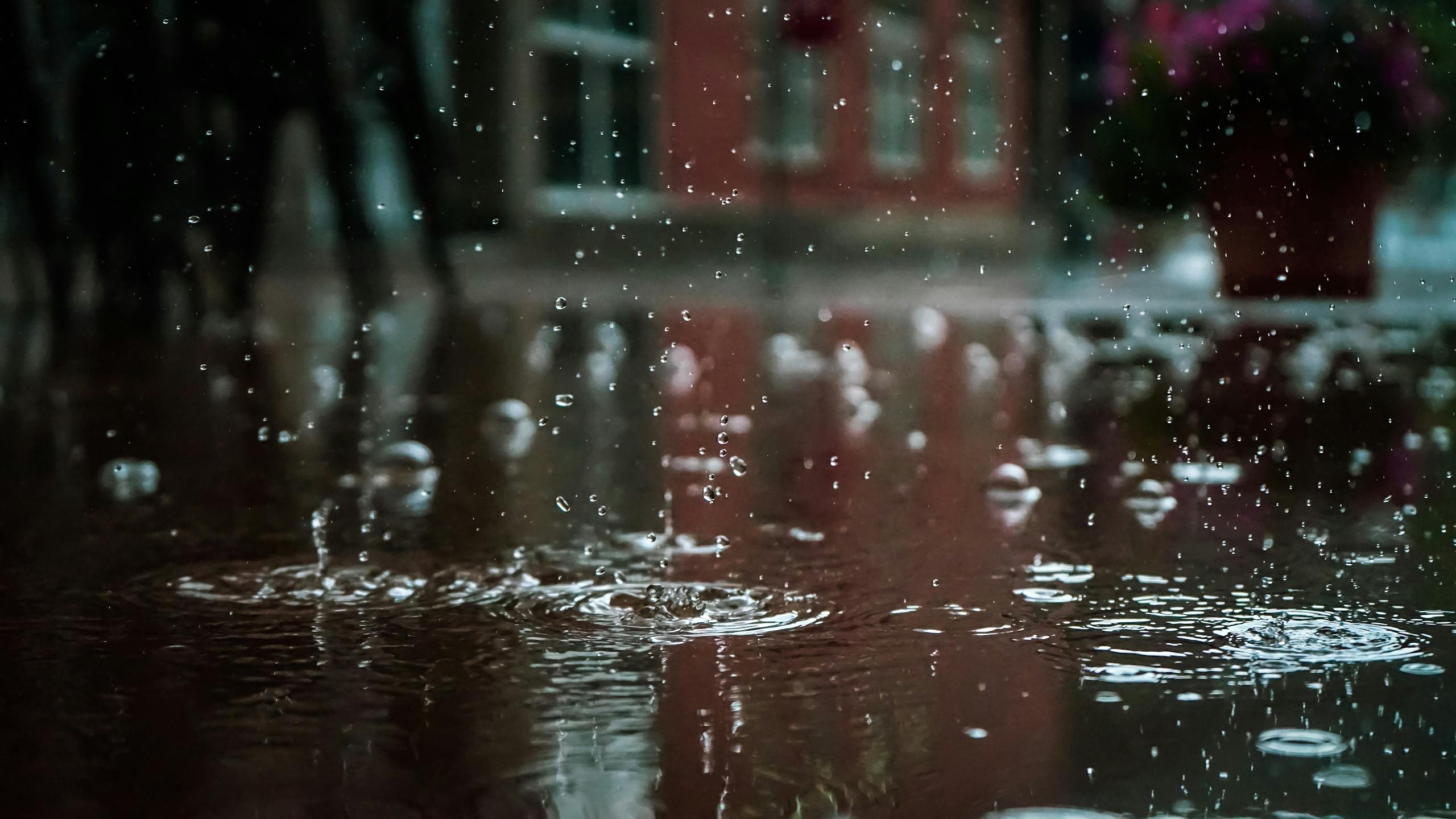 Gotas de chuva intensas formando poça em ambiente urbano, simbolizando o alerta de chuvas e o risco de alagamento no Espírito Santo.